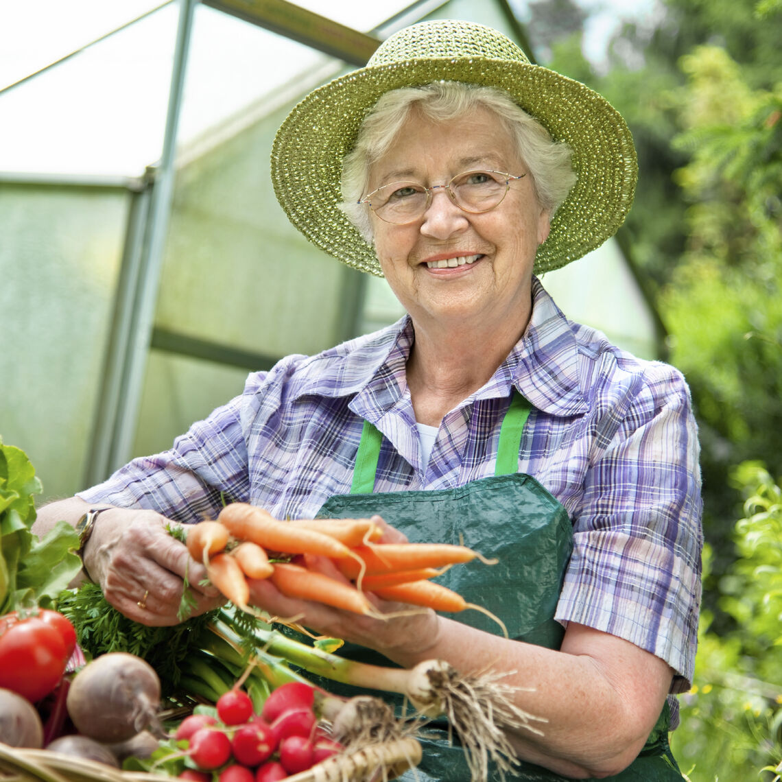 older woman holding fruits and vegetables in a basket